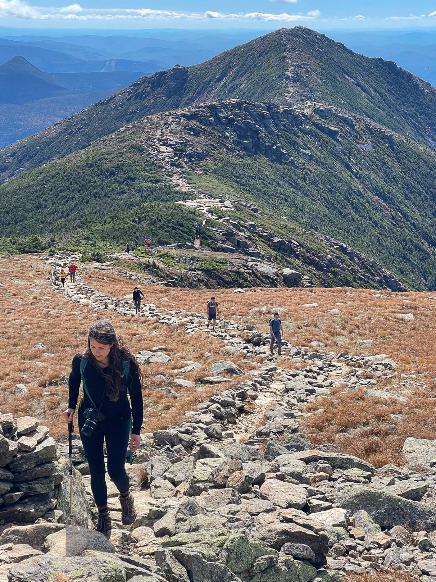 girl walking along a rocky mountaintop path