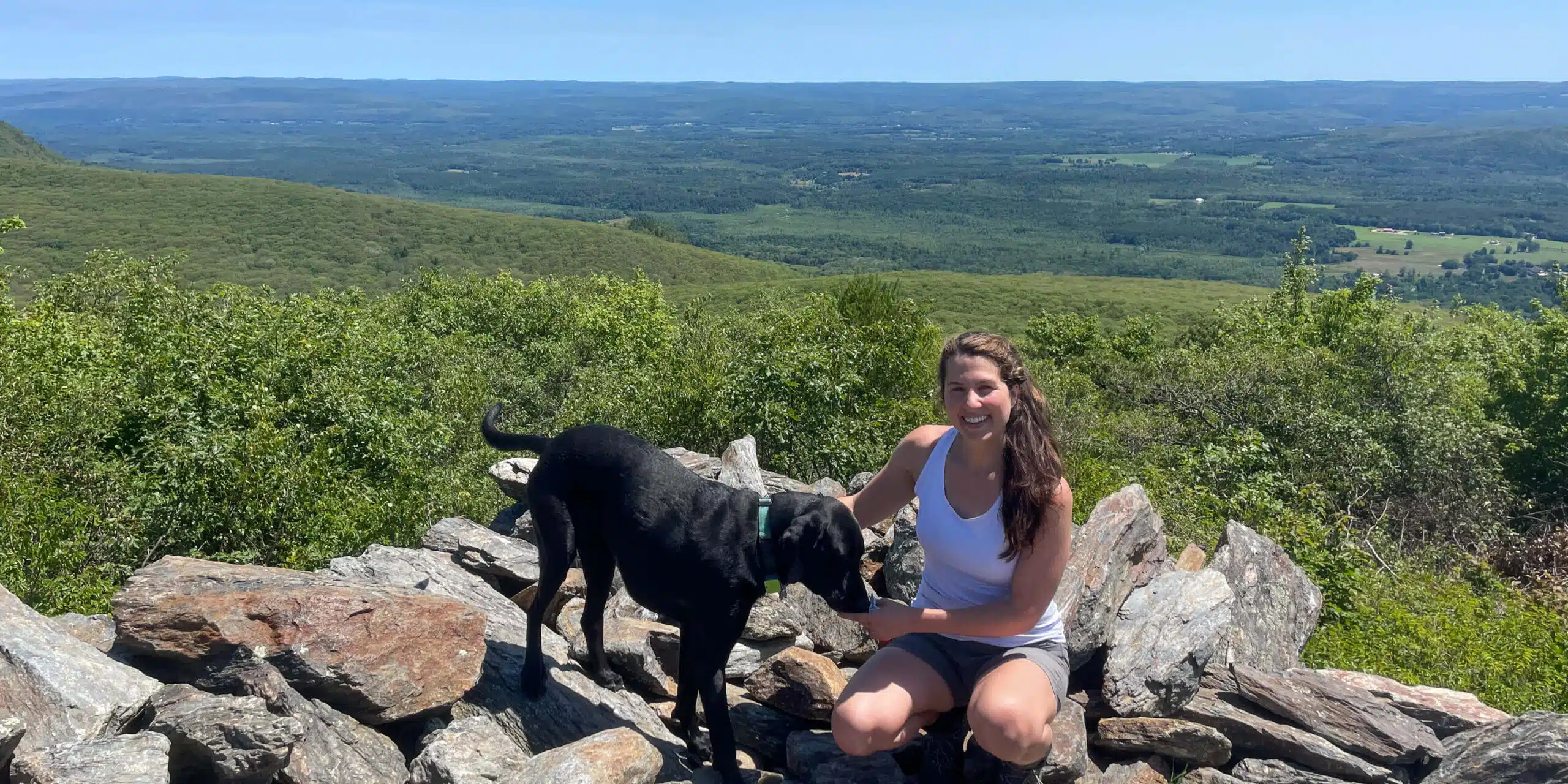 woman and dog on top of bear mountain in connecticut in summer