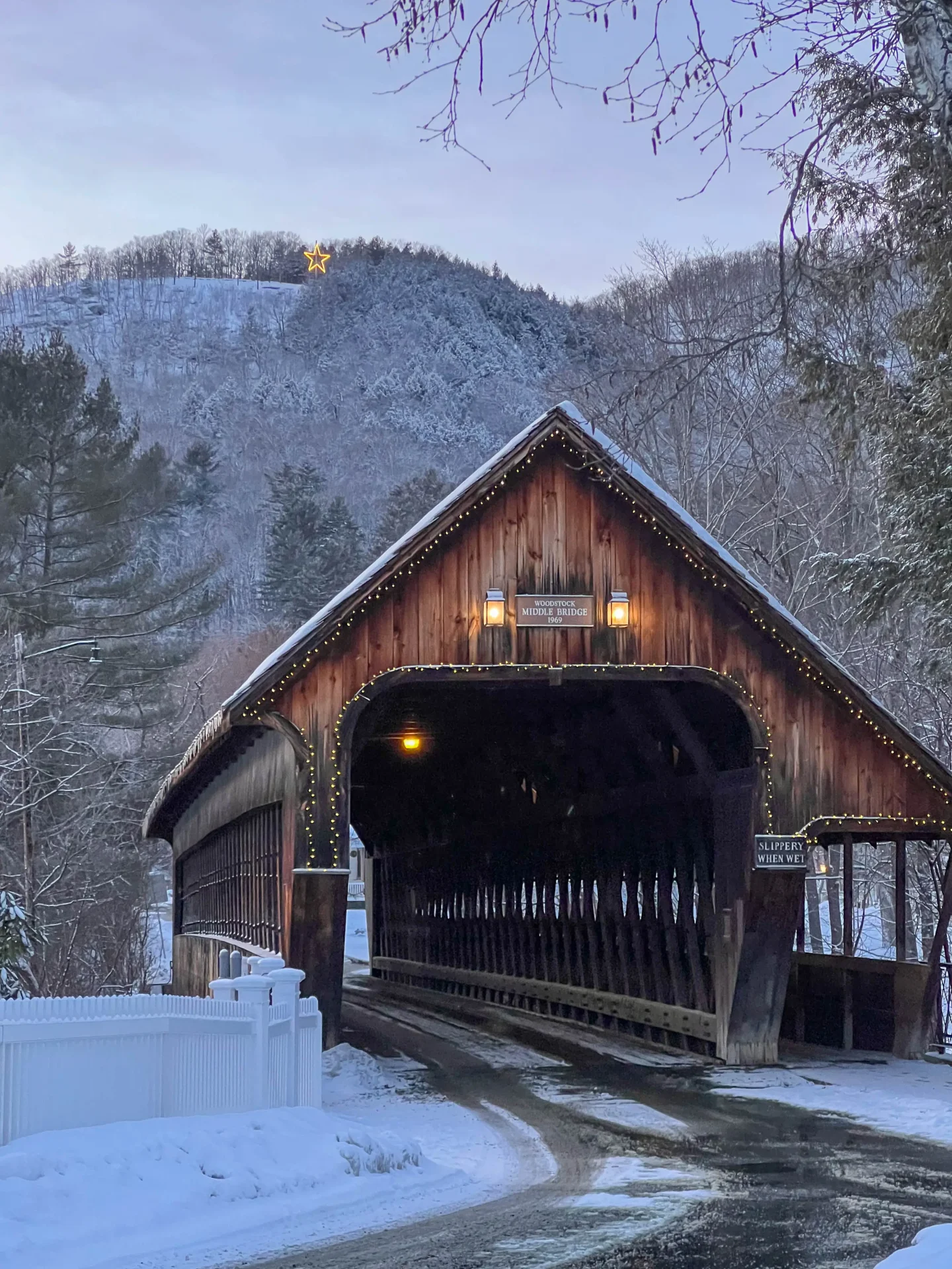 woodstock vermont covered bridge in winter with snow and pink sunset sky