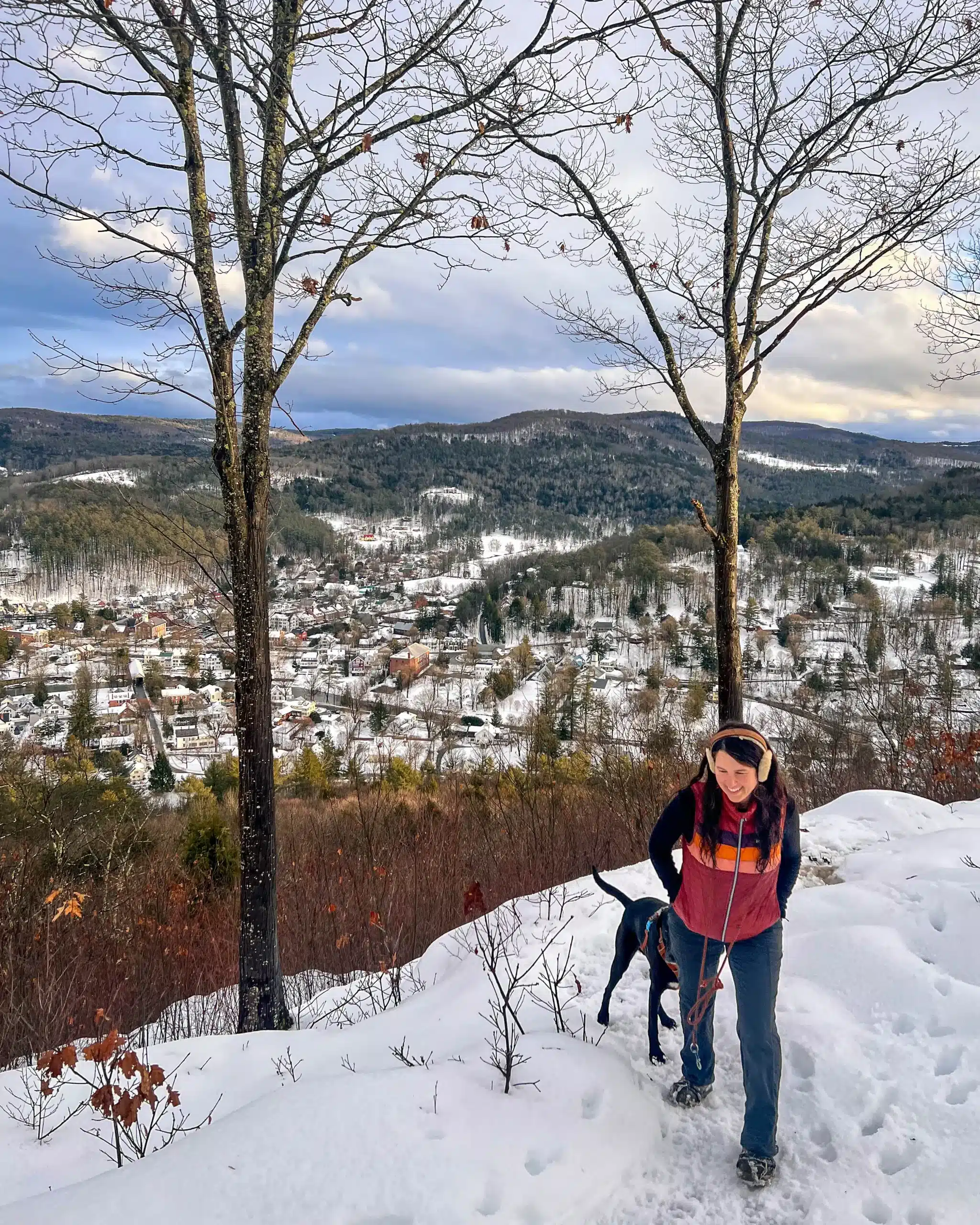 woman walking up a snowy trail at mount tom in woodstock vermont.