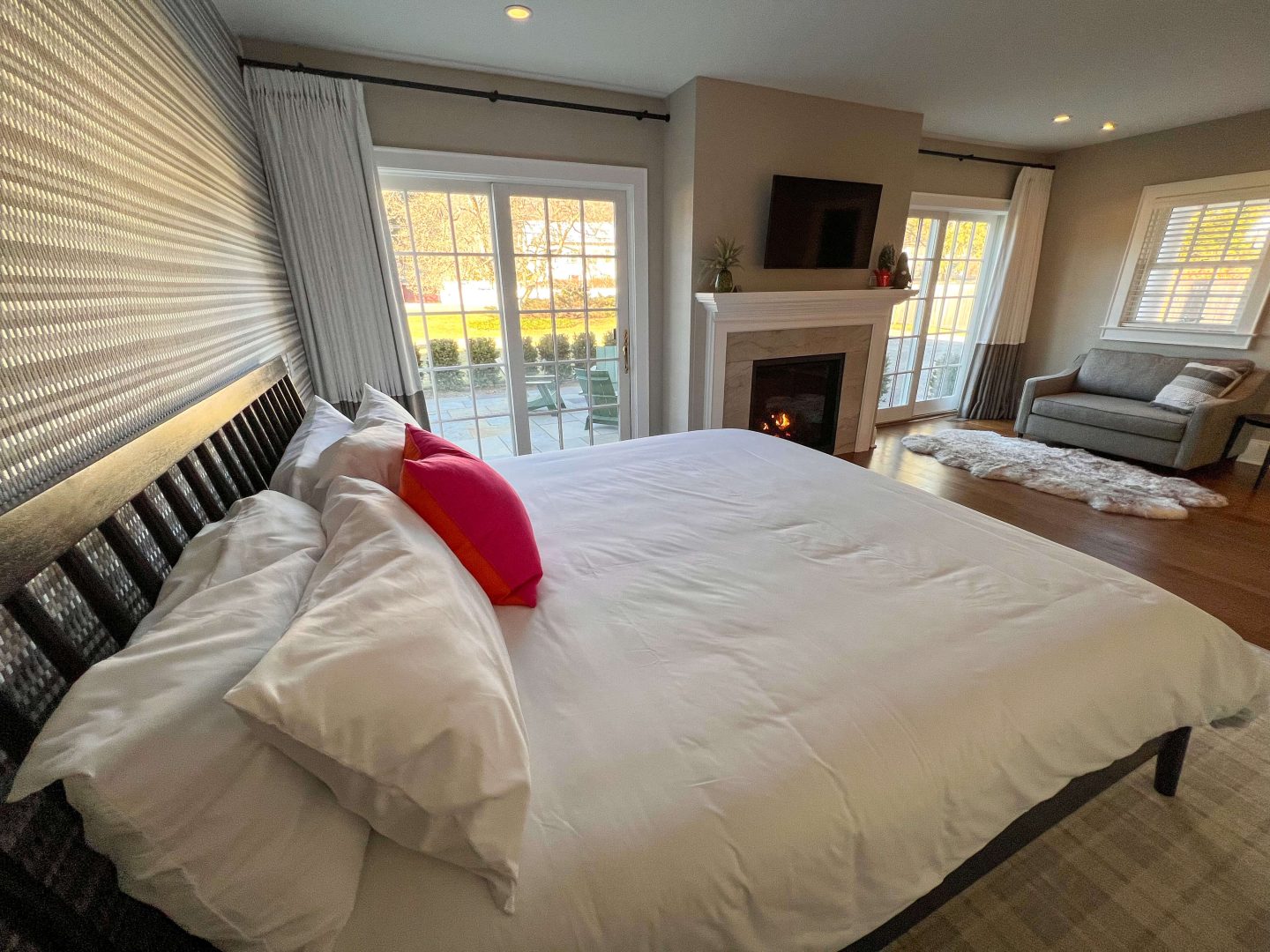 white bed in connecticut inn with fireplace in the room
