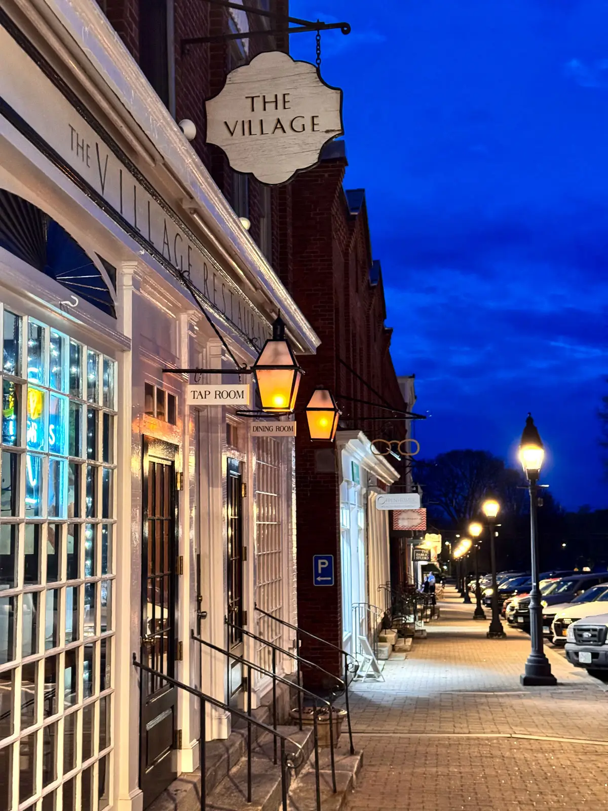 downtown litchfield at night with storefronts and lights.