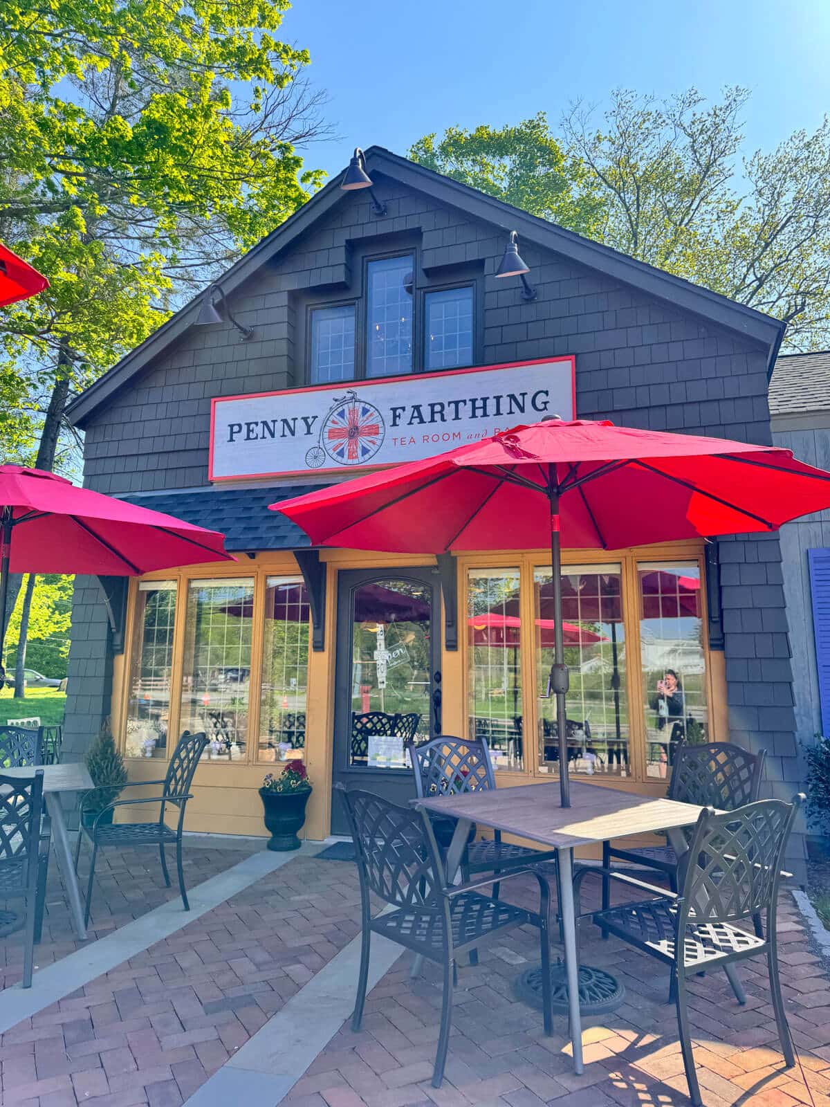 outside of penny farthing british tea room just outside of litchfield with red umbrellas at outdoor tables.