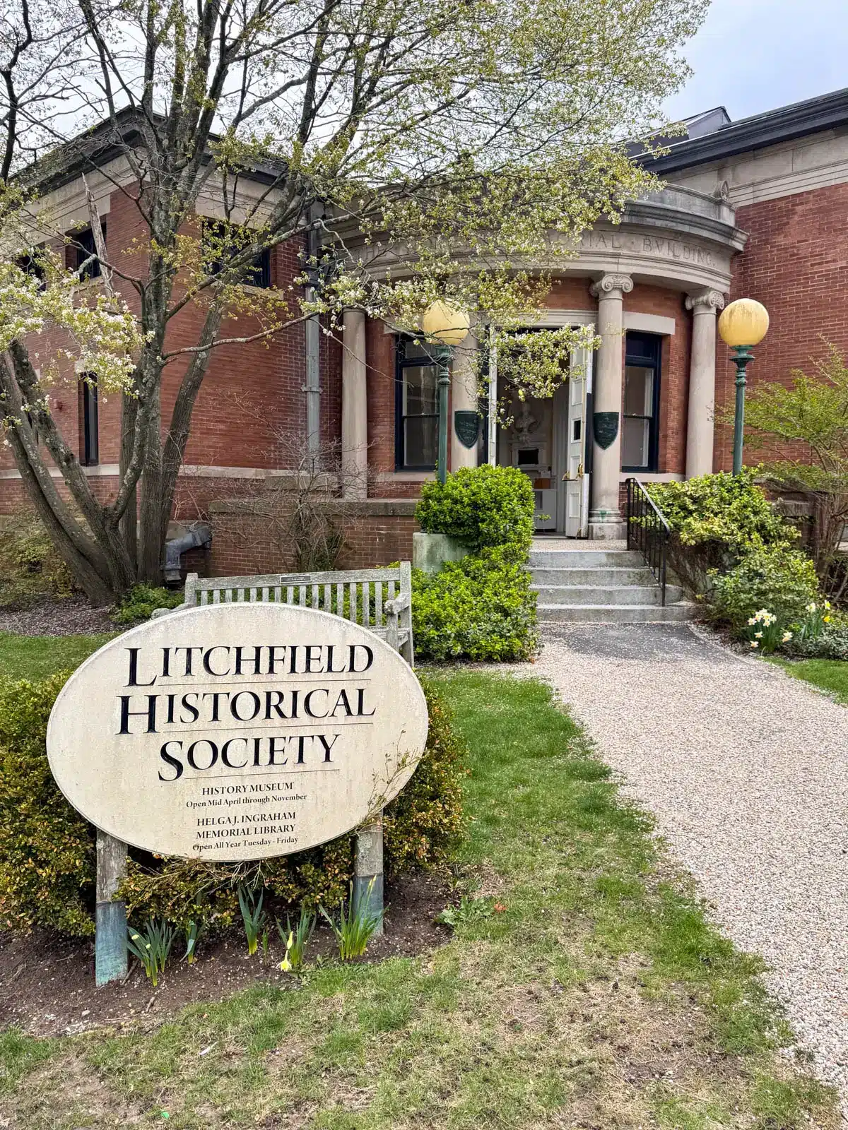 outside of brick litchfield historical society with green grass leading up to it.