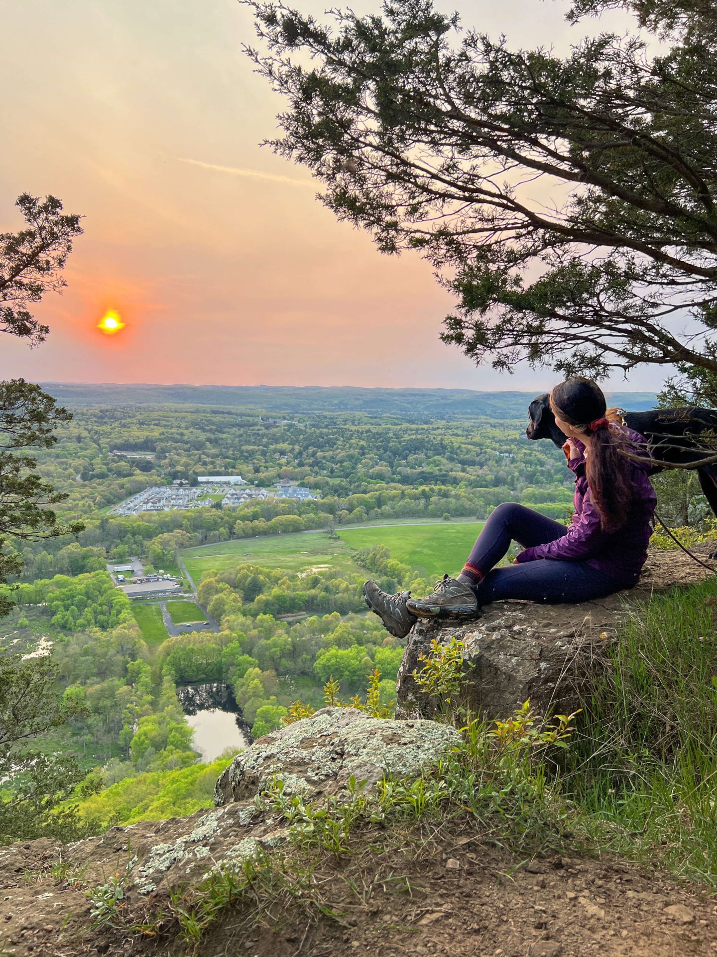 woman and dog on top of talcott mountain at sunset time in summer