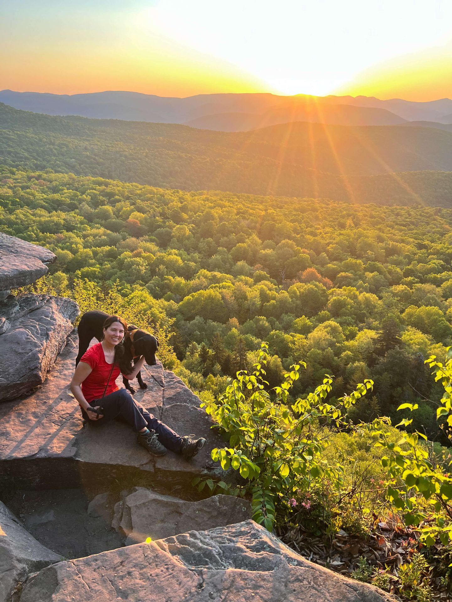 woman and black dog on hike at sunrise near tannersville ny