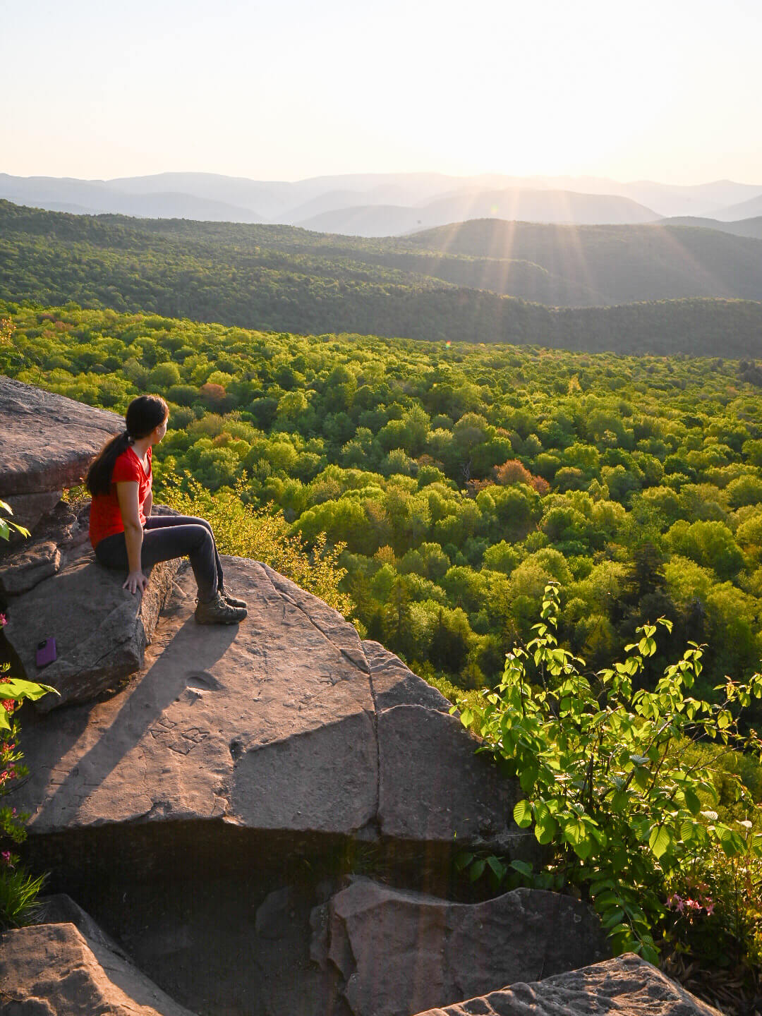 woman on giant ledge at sunrise hike near tannersville new york