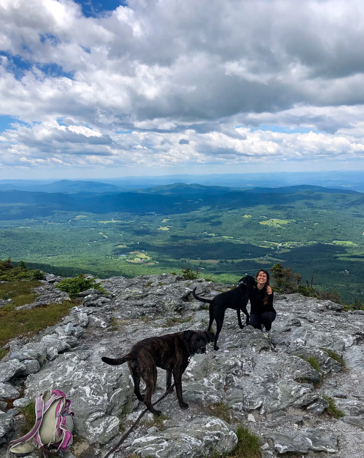 woman and dogs smiling on top of mount abraham hike in vermont