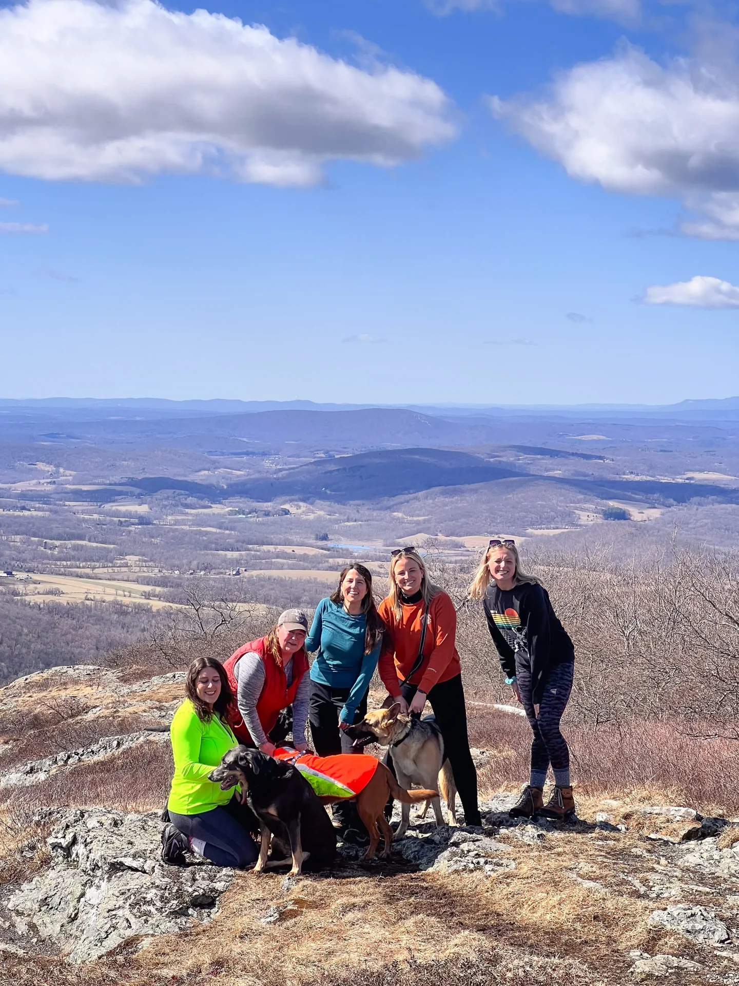 group of women atop alander mountain in massachusetts in early spring with bare mountains