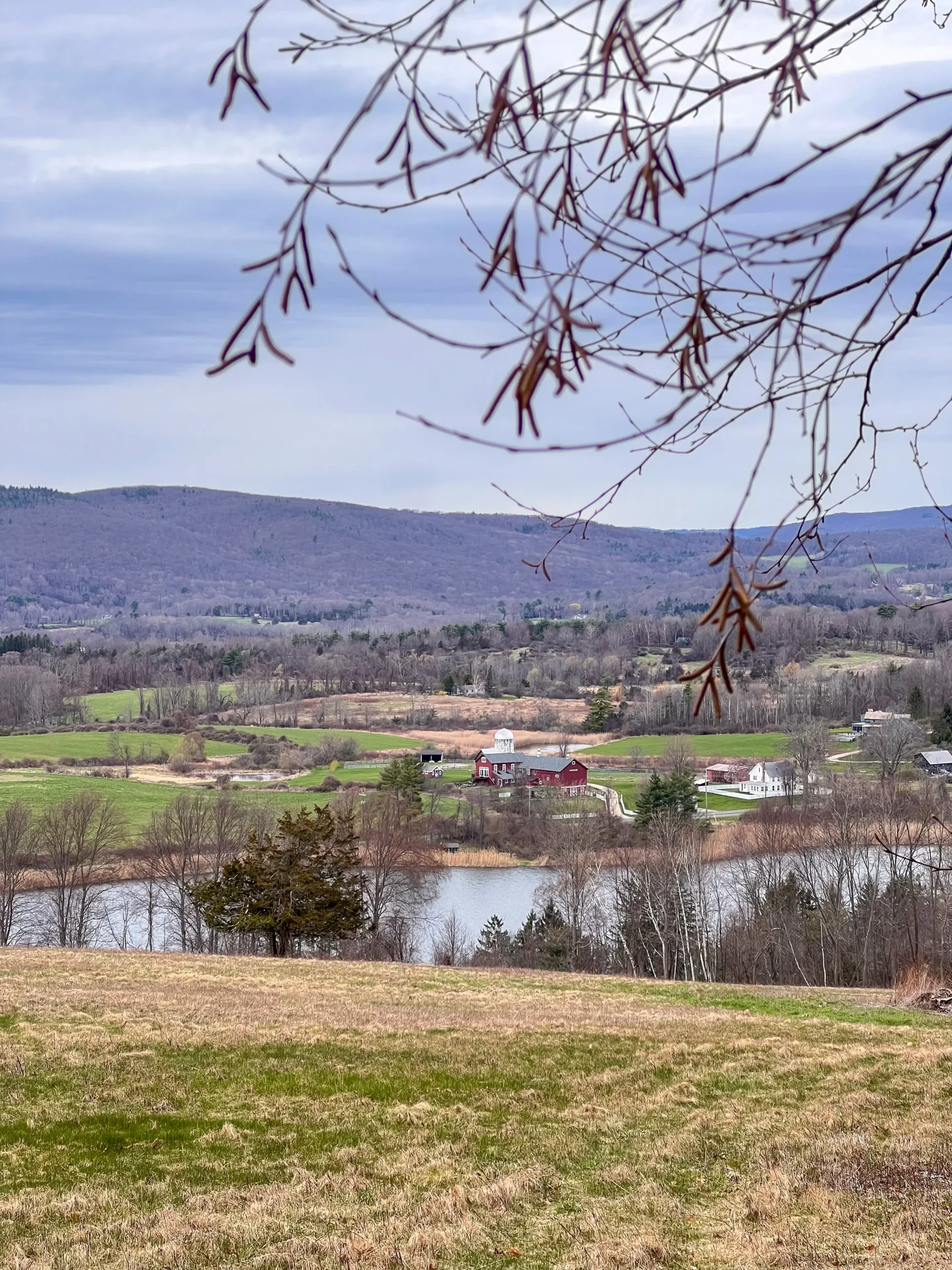 early spring view of hills and red barn at view at mary moore preserve in spring in sharon connecticut