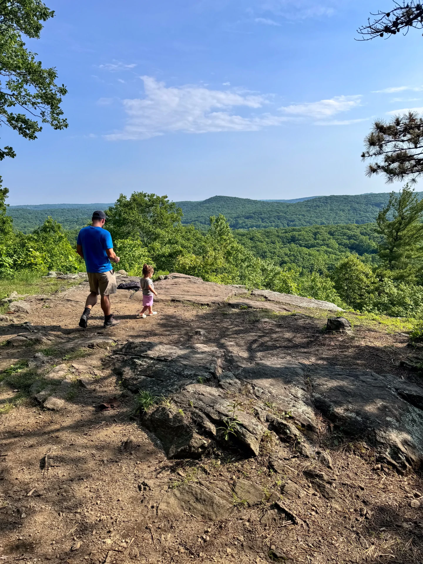 man and baby at hemlock hills pine mountain in ridgefield with green mountains and trees in backyard