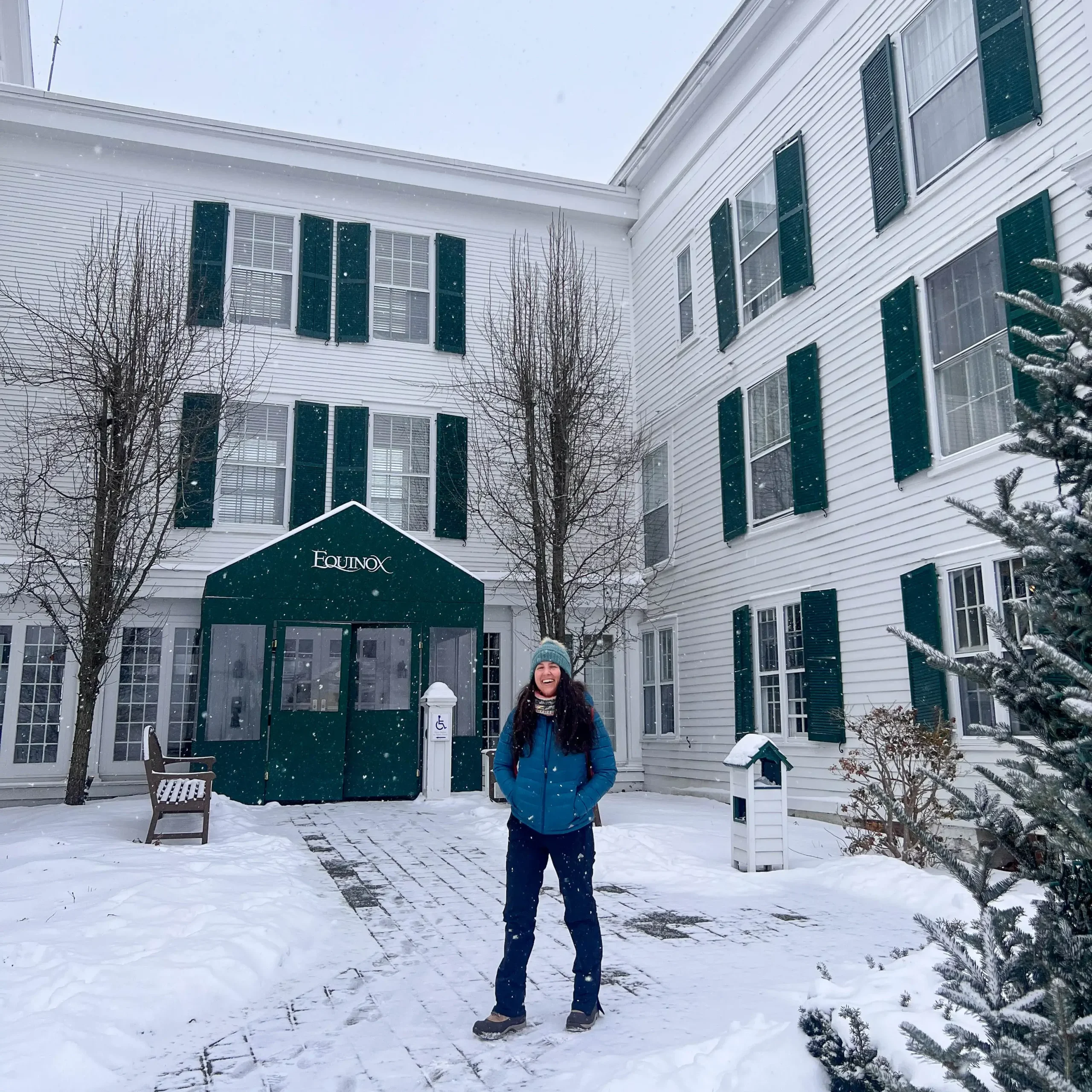 woman smiling in front of equinox resort in new england