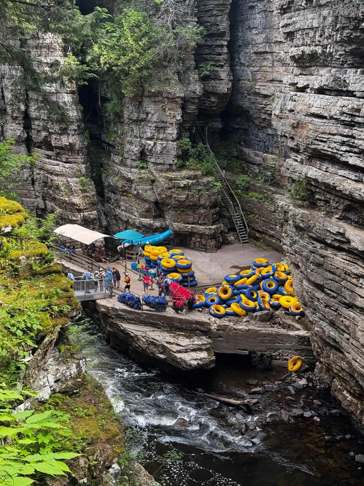 line of people getting in yellow tubes in rocky canyon.