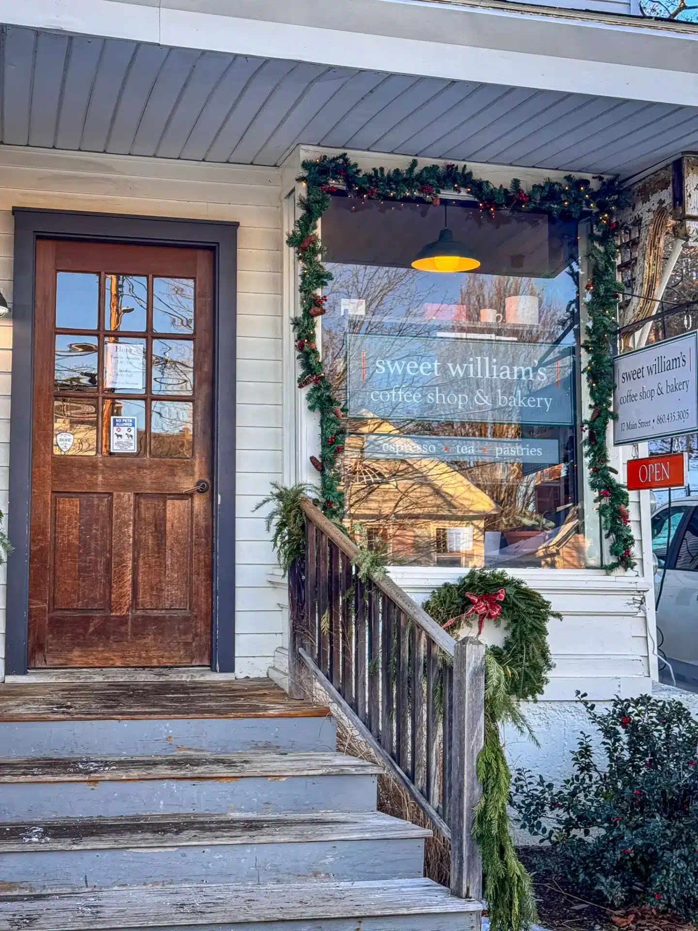 outside of sweet williams bakery with wooden door and Christmas decorations