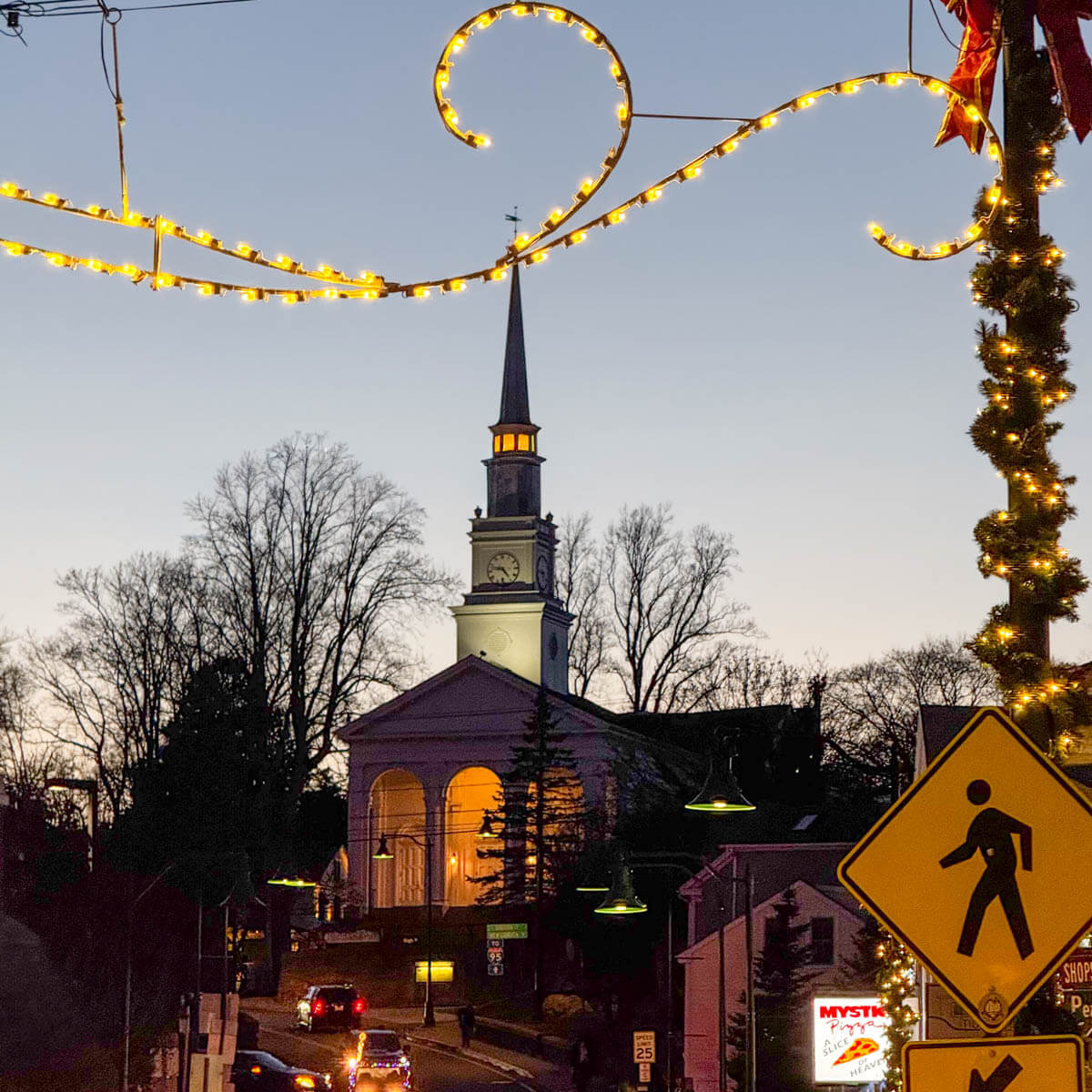sunset time photo of downtown mystic with church steeple in the distance.