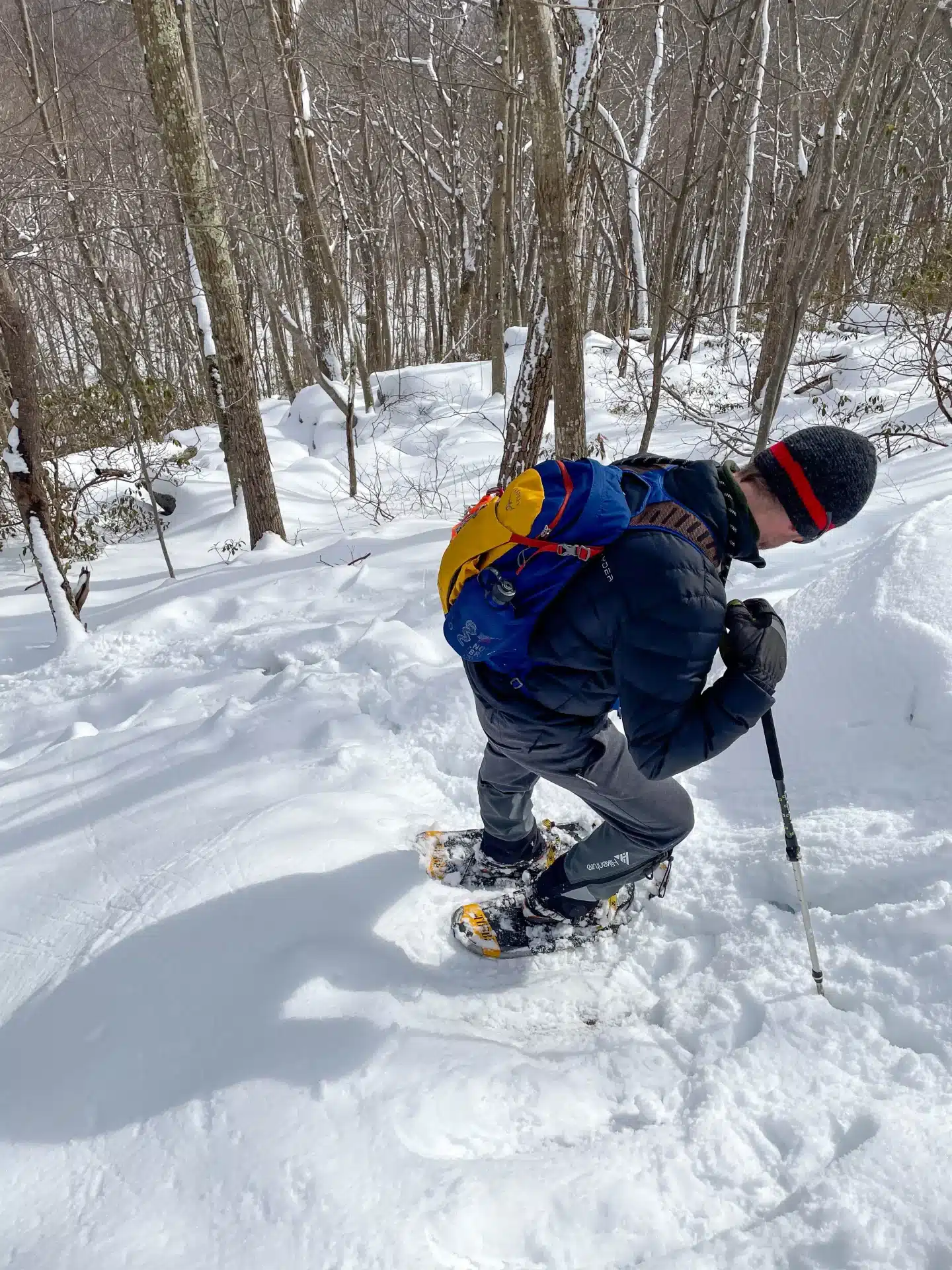 man winter hiking with snowshoes at cobble mountain in connecticut