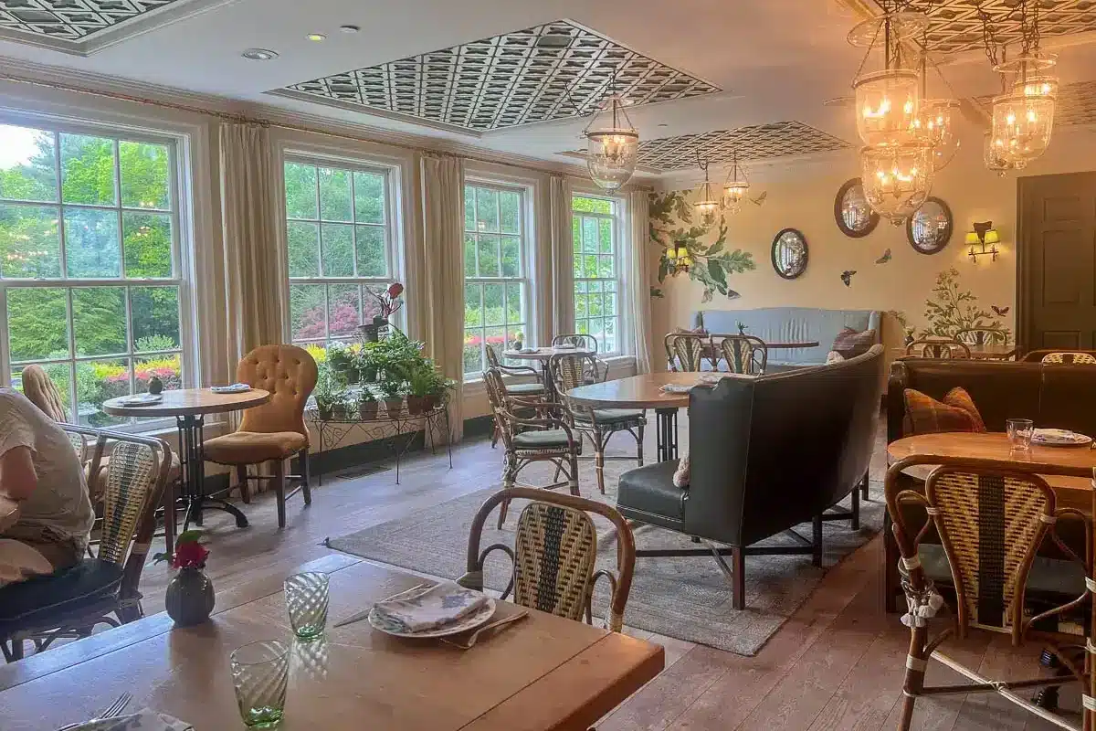 brunch room at the mayflower inn in washington depot with plants and soft lighting and windows to the outside