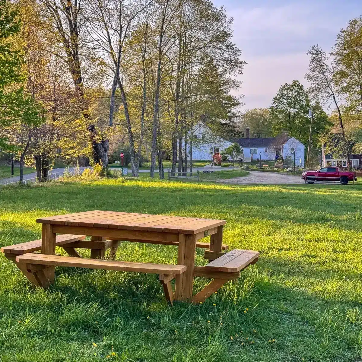 wooden picnic table on green grass at flanders nature center in connecticut
