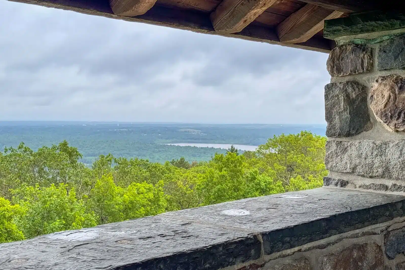 view from stone Eliot Tower in Blue Hills Reservation with view of rolling green hills in the distance.