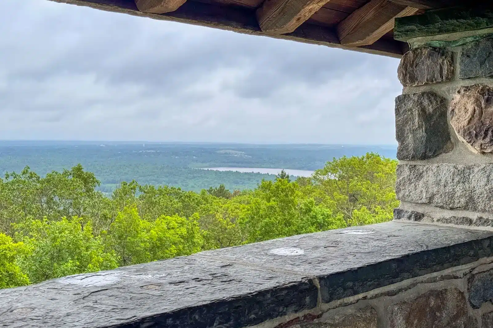 view from stone Eliot Tower in Blue Hills Reservation with view of rolling green hills in the distance.