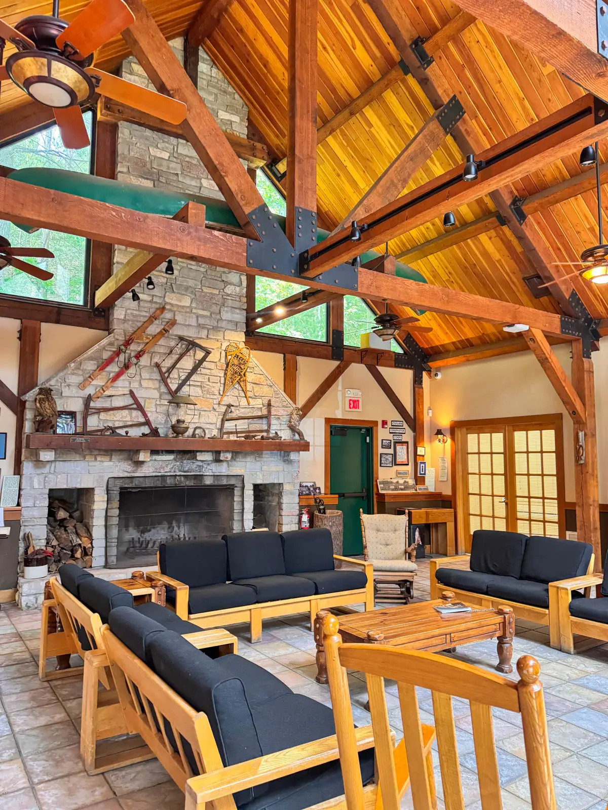 inside of large cabin room with wood beams and couches.