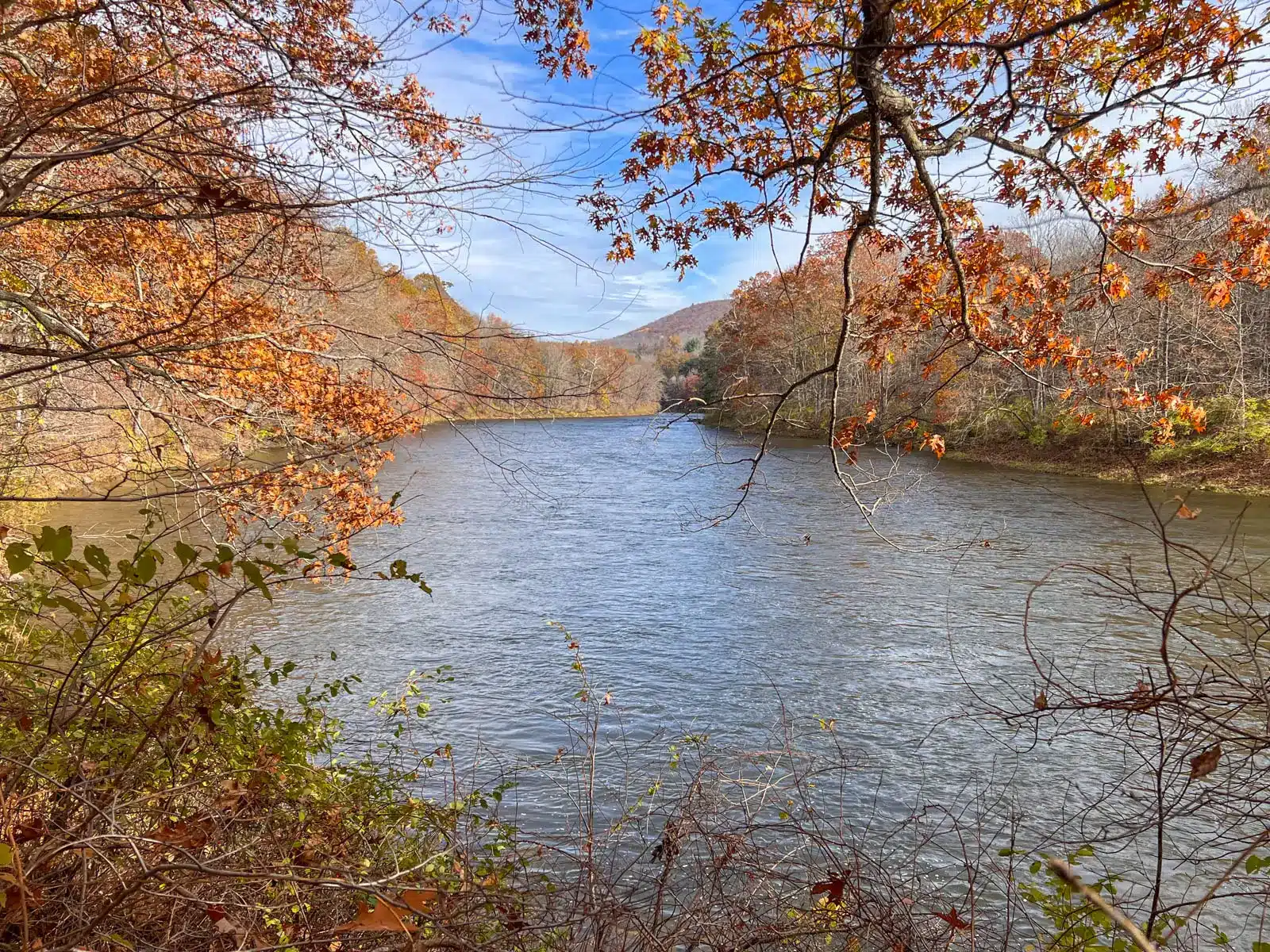 housatonic river surrounded by orange leaves in fall in connecticut.
