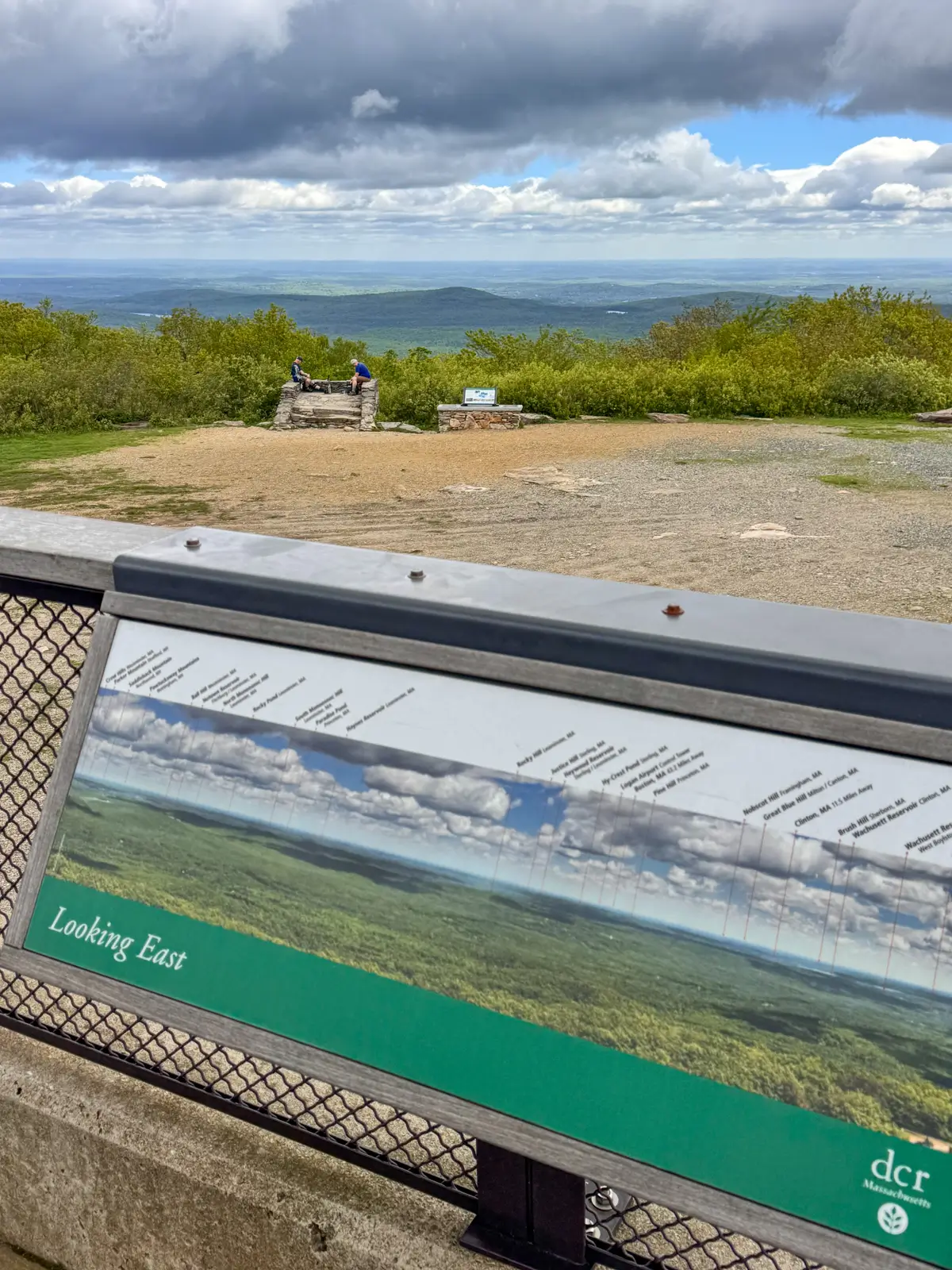 view from the top of mount wachusett with green trees in background.
