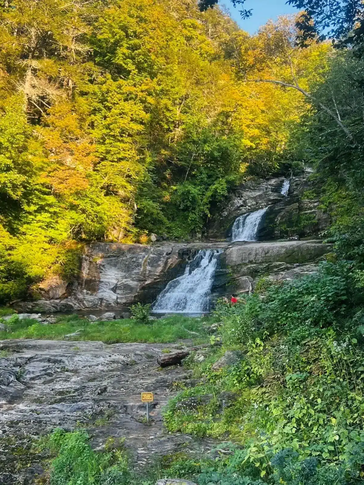 kent falls waterfall with yellow leaves surrounding it.