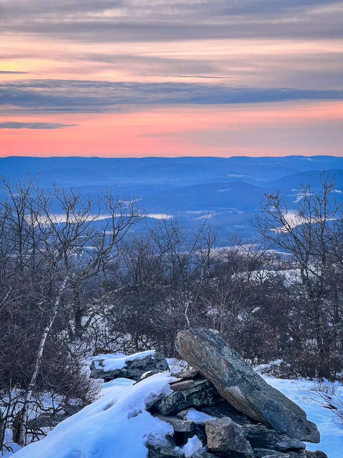 sunrise with soft pink sky atop a snowy mount race in massachusetts.