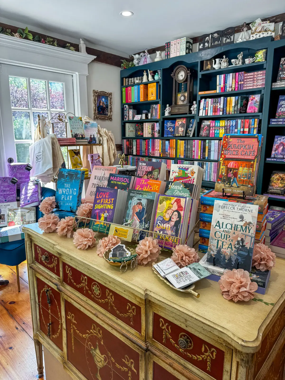inside Montgomery & Taggert Bookshop in Chester, CT, with bright but small room lined with brightly colored books and a comfy chair in left corner of room.