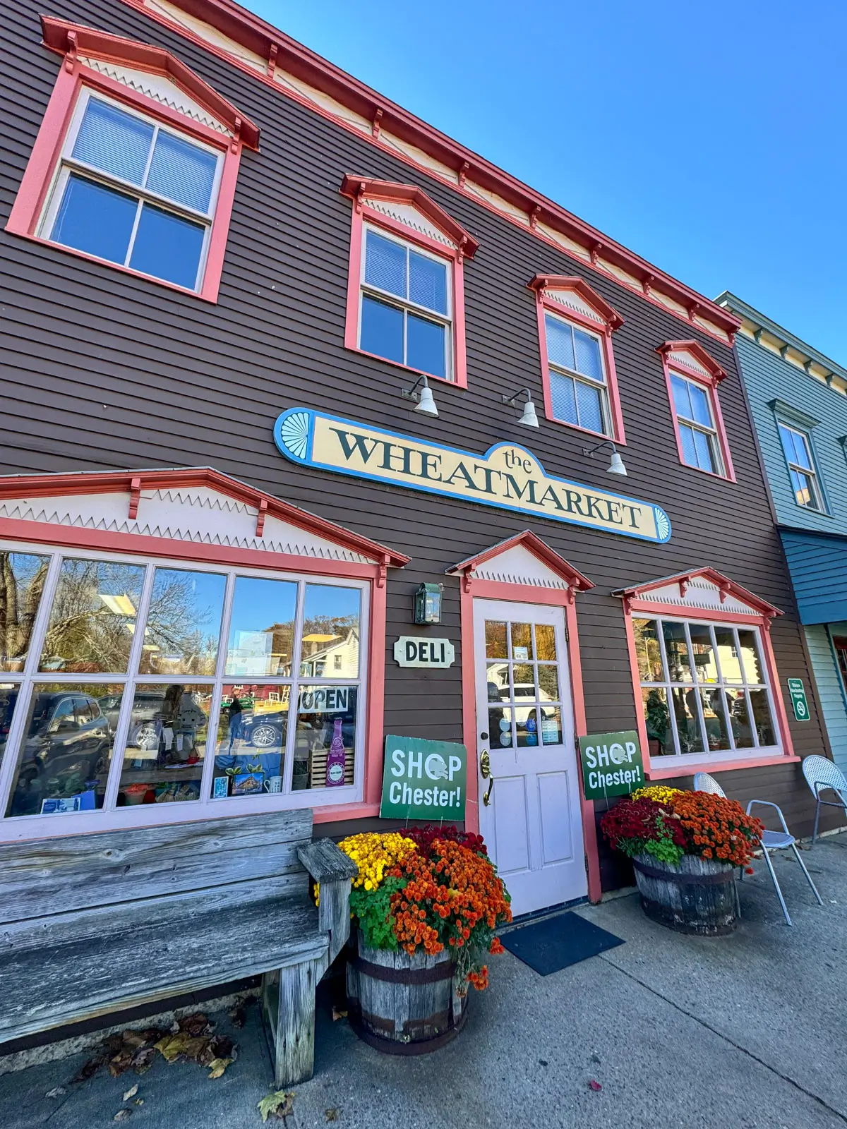 Storefront of brown colonial house building with with red trim and large Wheatmarket sign in chester, ct.
