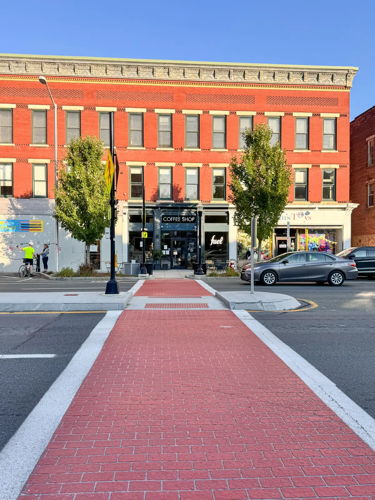 downtown main street in great barrington with red brick path running across the strees and old archictecture buildings lining the street in the background with blue sky above.