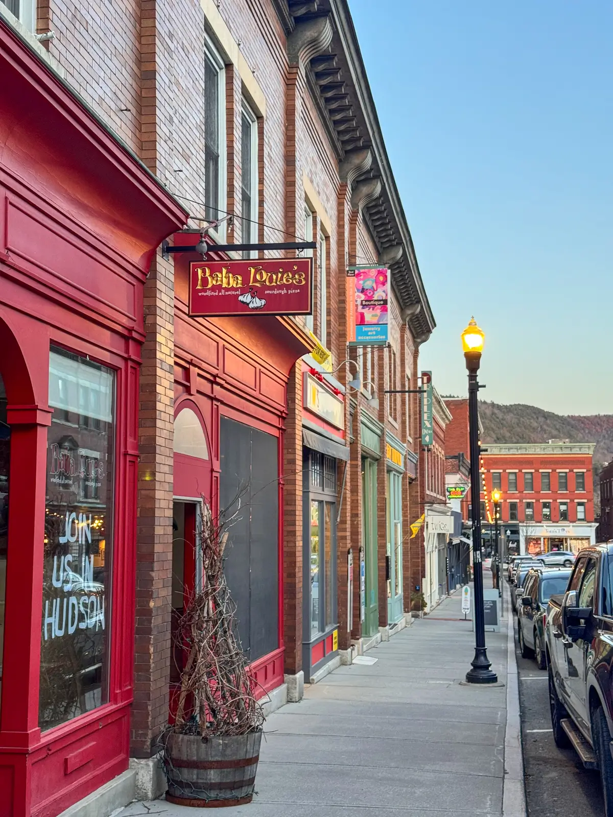 downtown great barringon railroad street at dusk with a clear sky and buildings and storefronts lit up.