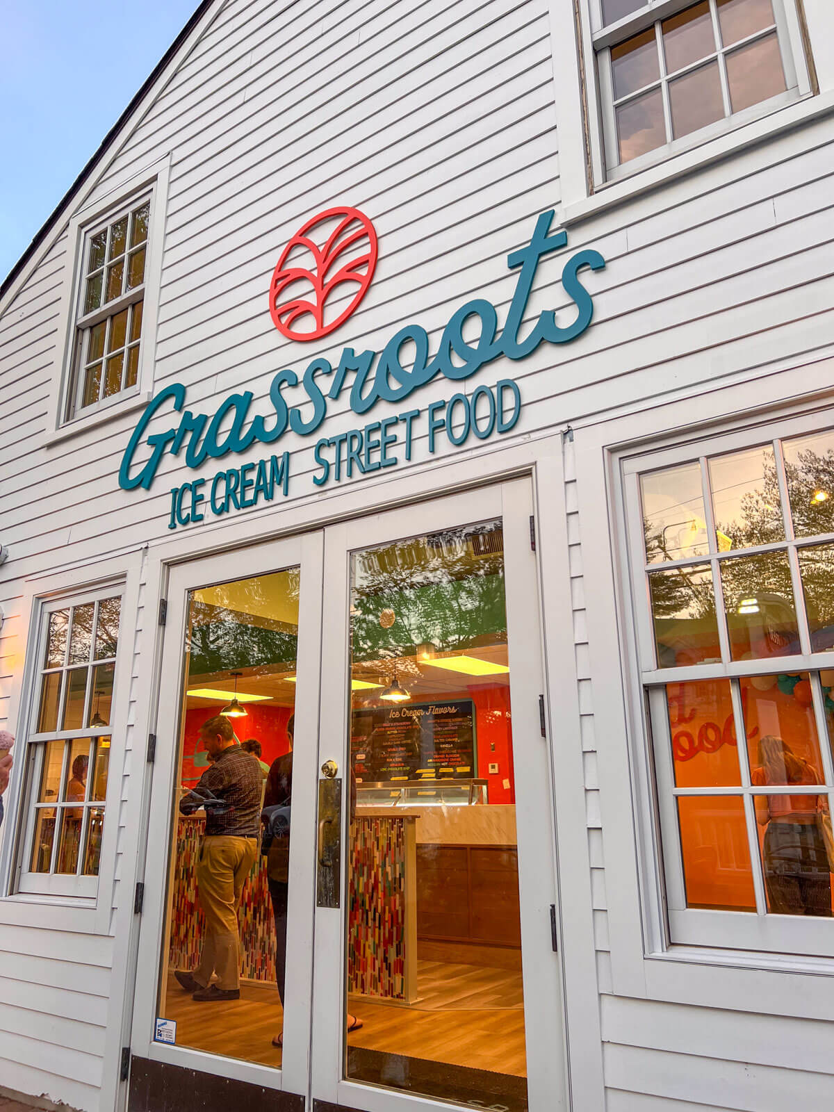 outside of grassroots cafe in simsbury with white building and blue grassroots word.