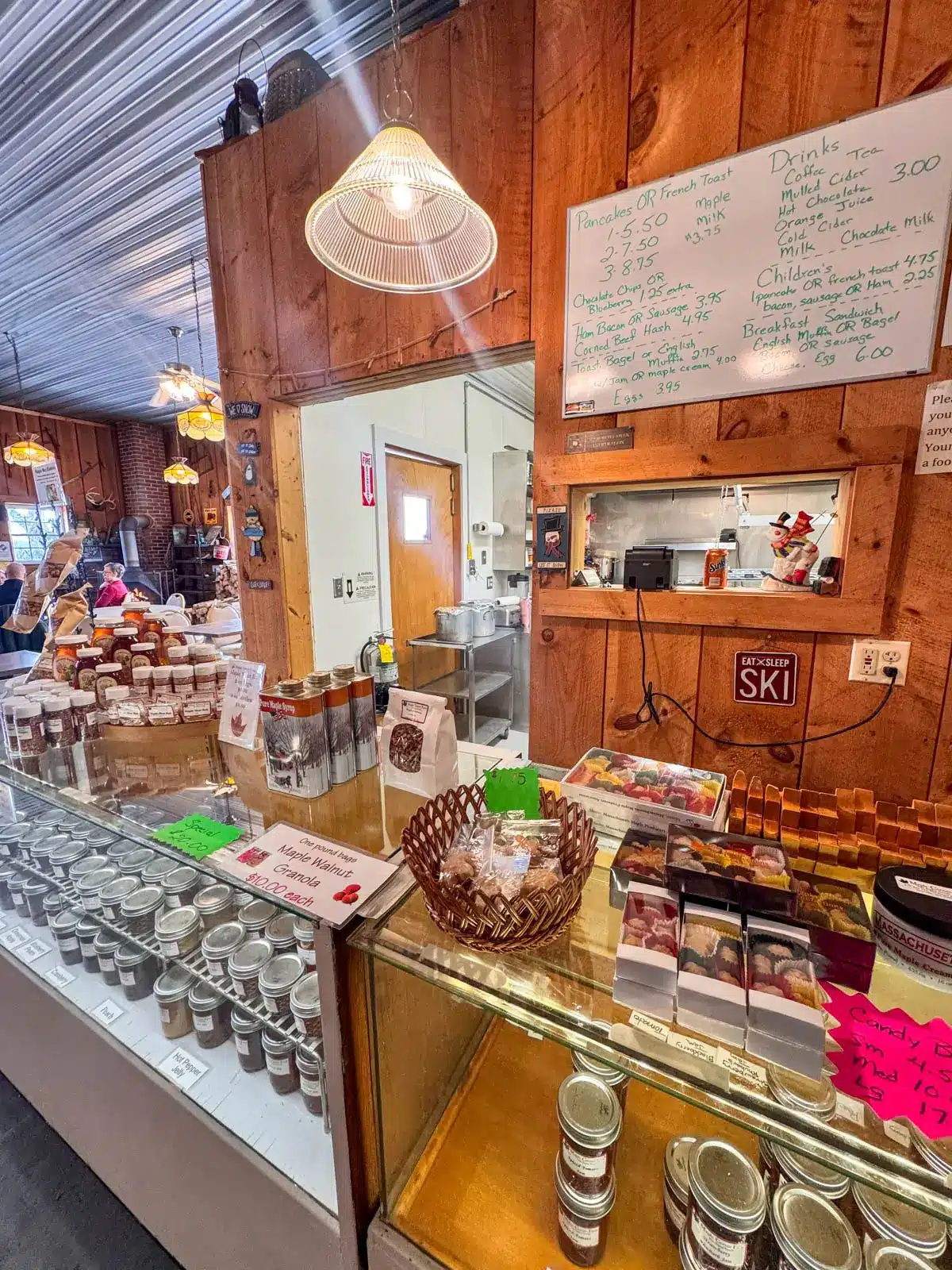 inside maple corner farm with glass case of maple syrup bottles.