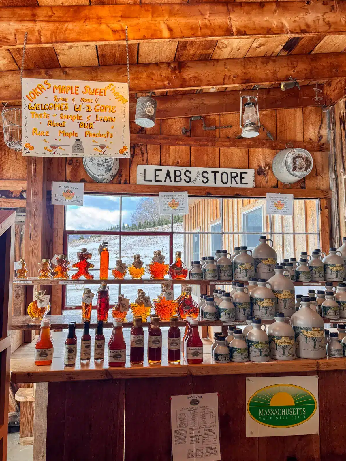 inside a maple syrup shop with multiple shelves lined with maple syrup bottles.