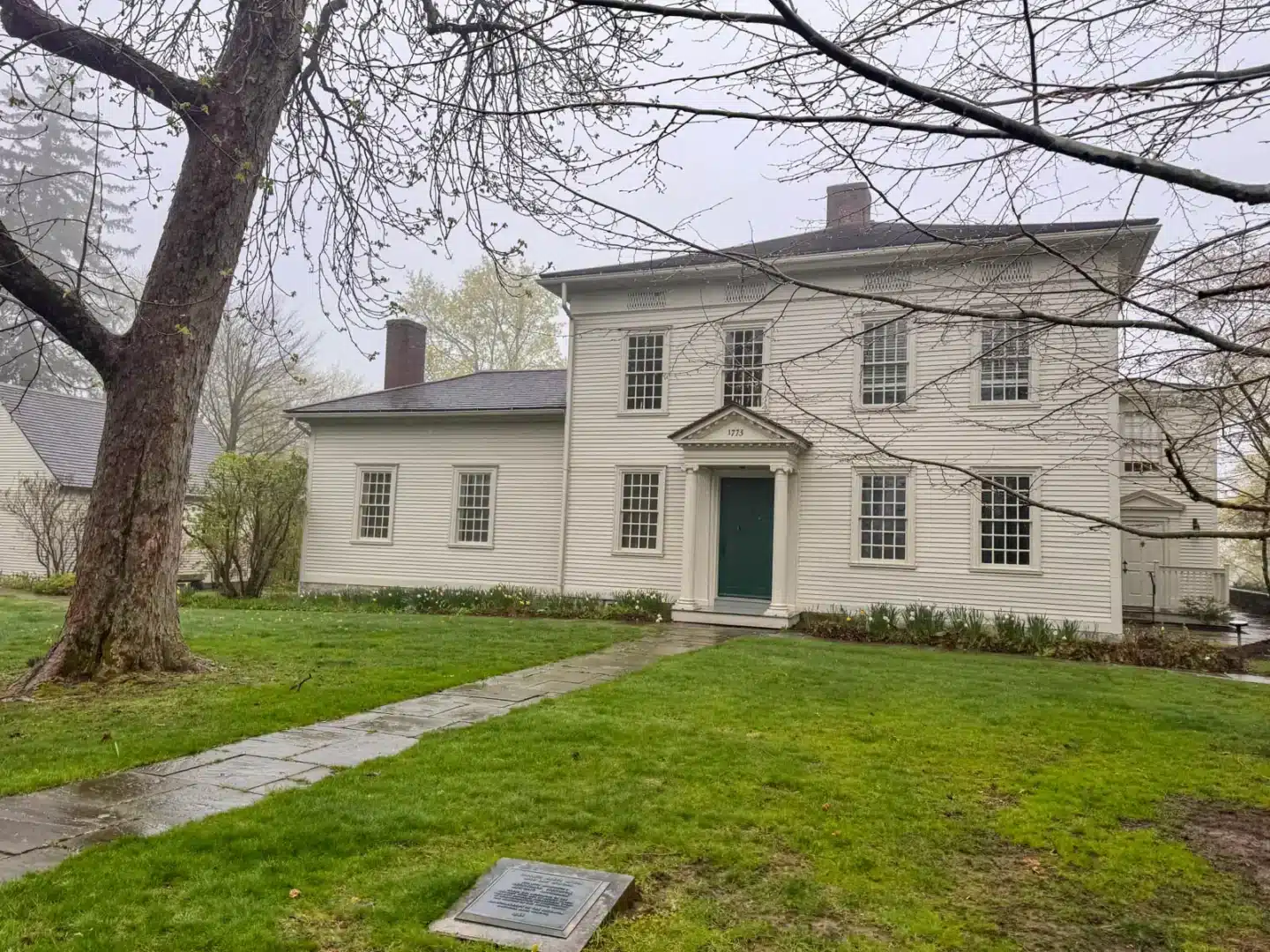 historic old colonial with bright green grass on foggy day in downtown litchfield.