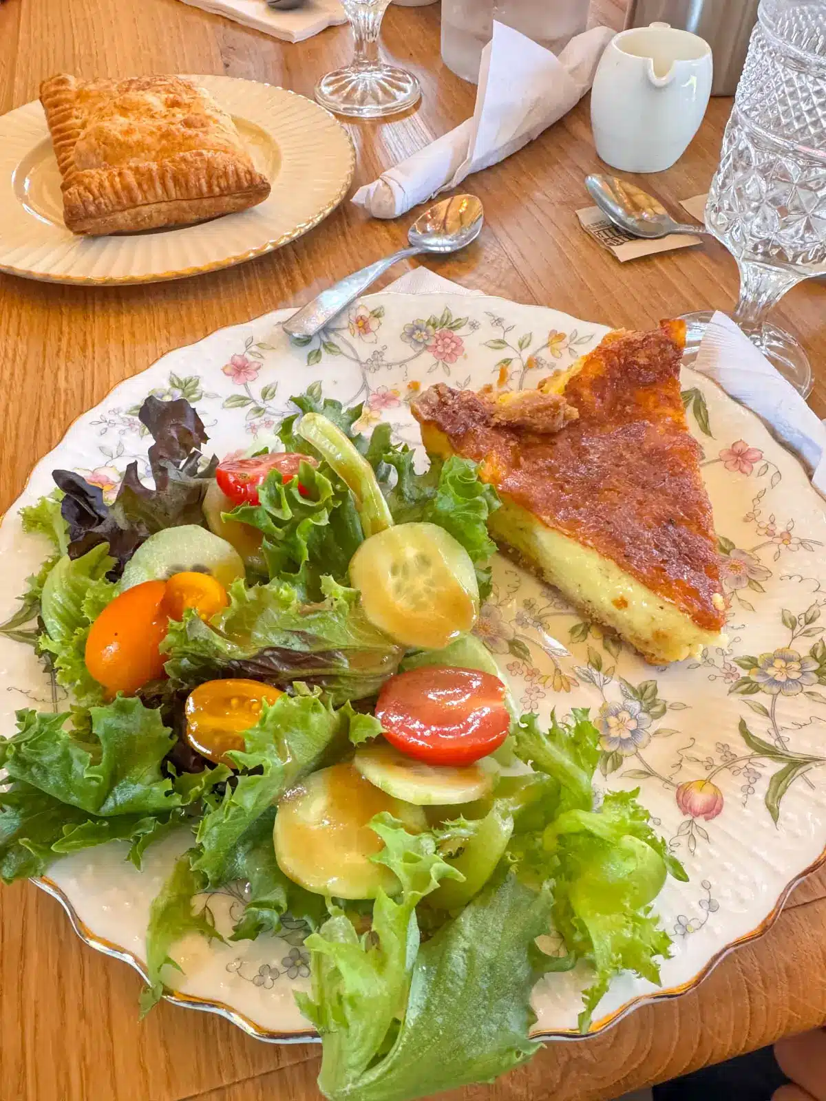 flower plate with a quiche and green salad on it.
