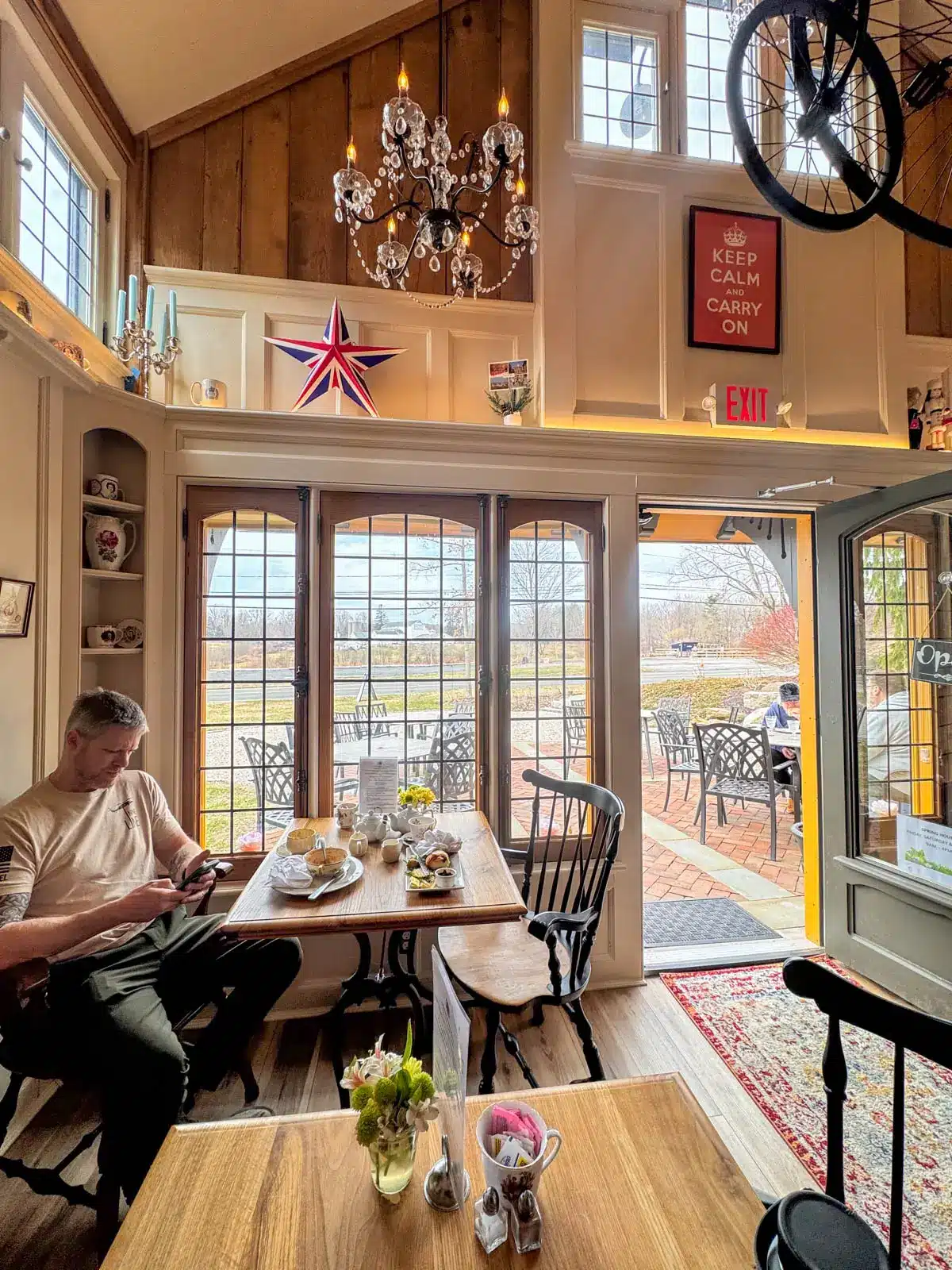 inside of penny farthing tea shop in litchfield connecticut with wooden tables and chairs with door open in spring.