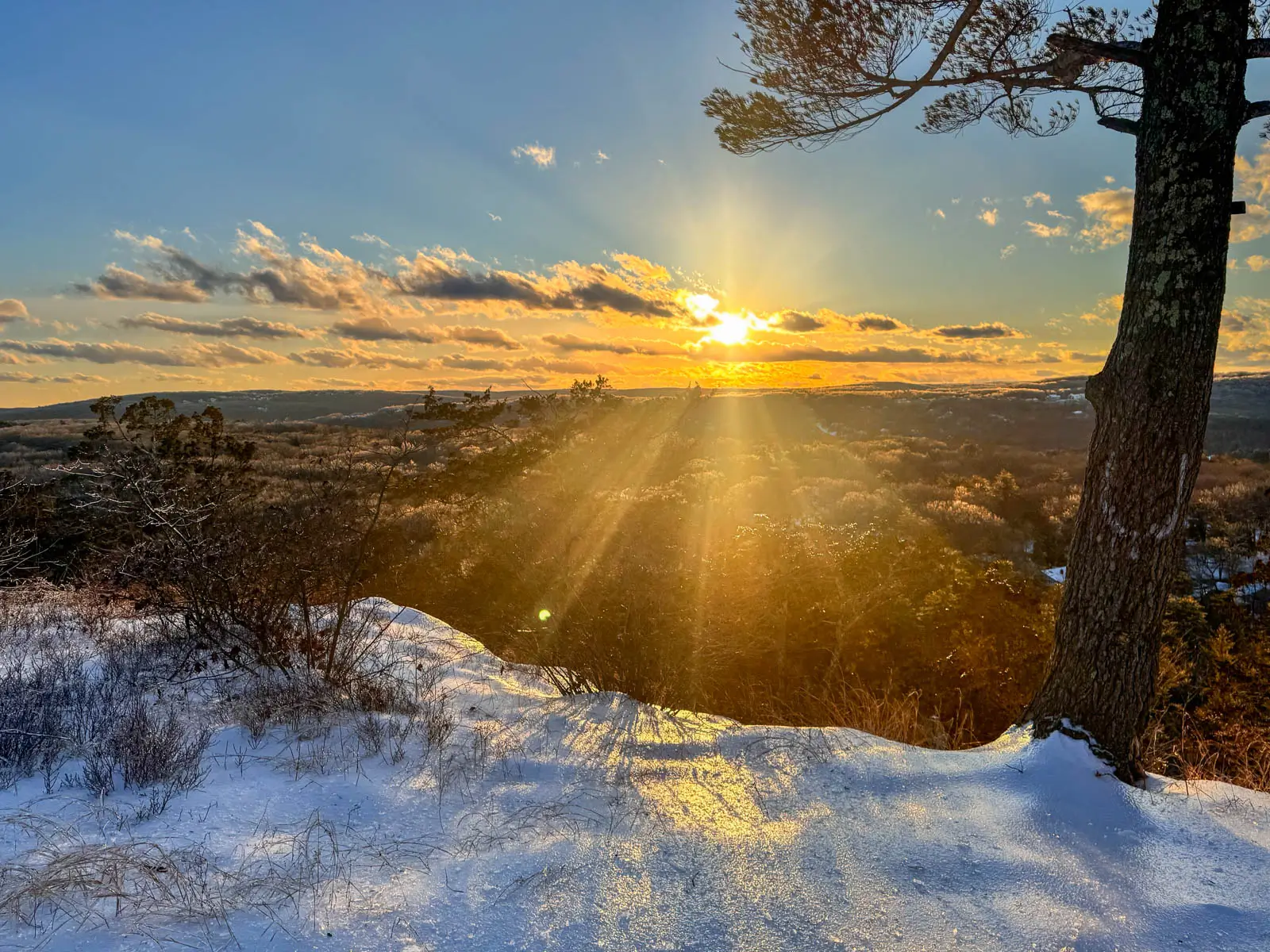 golden sun setting from snowy hike in Connecticut.