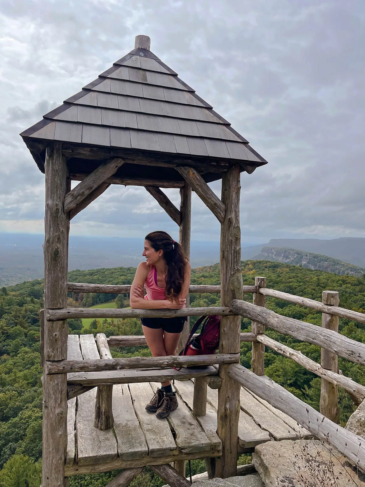 woman standing in mountaintop gazebo at mohonk preserve in new york.