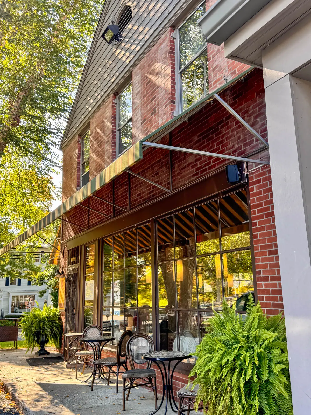 storefront of brick restaurant with windows reflecting the golden light,