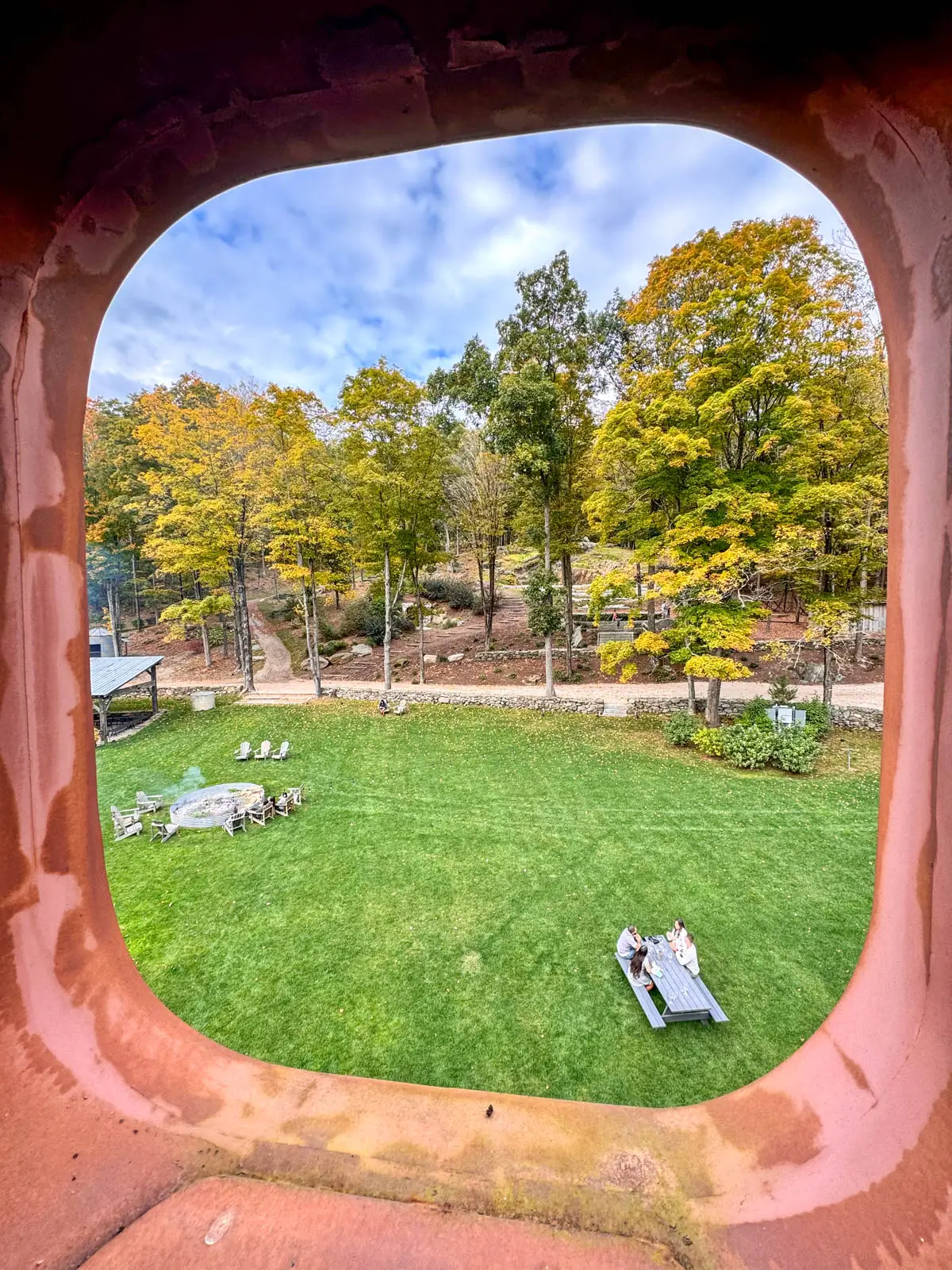 view from top of tower at spring hill vineyards in litchfield county with picnic tables sprinkled over green lawn and yellow trees lining the property.