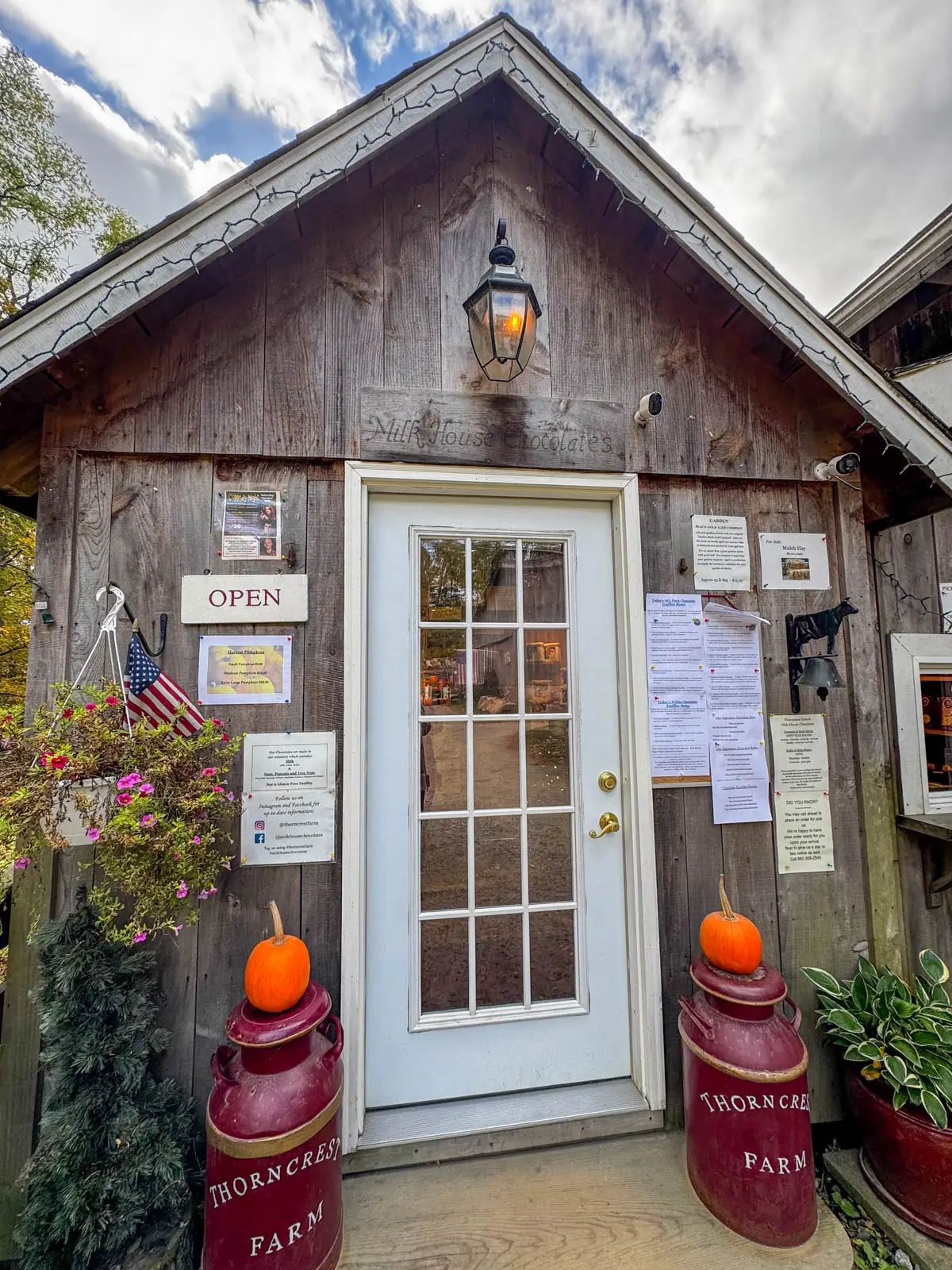 barn entrance to thorncrest farm in Litchfield County with two small pumpkins on either side of front door.