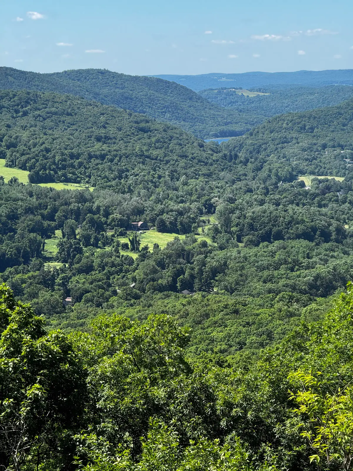 view of rolling hills and a green valley from a hike in connecticut on a summer day in Connecticut.