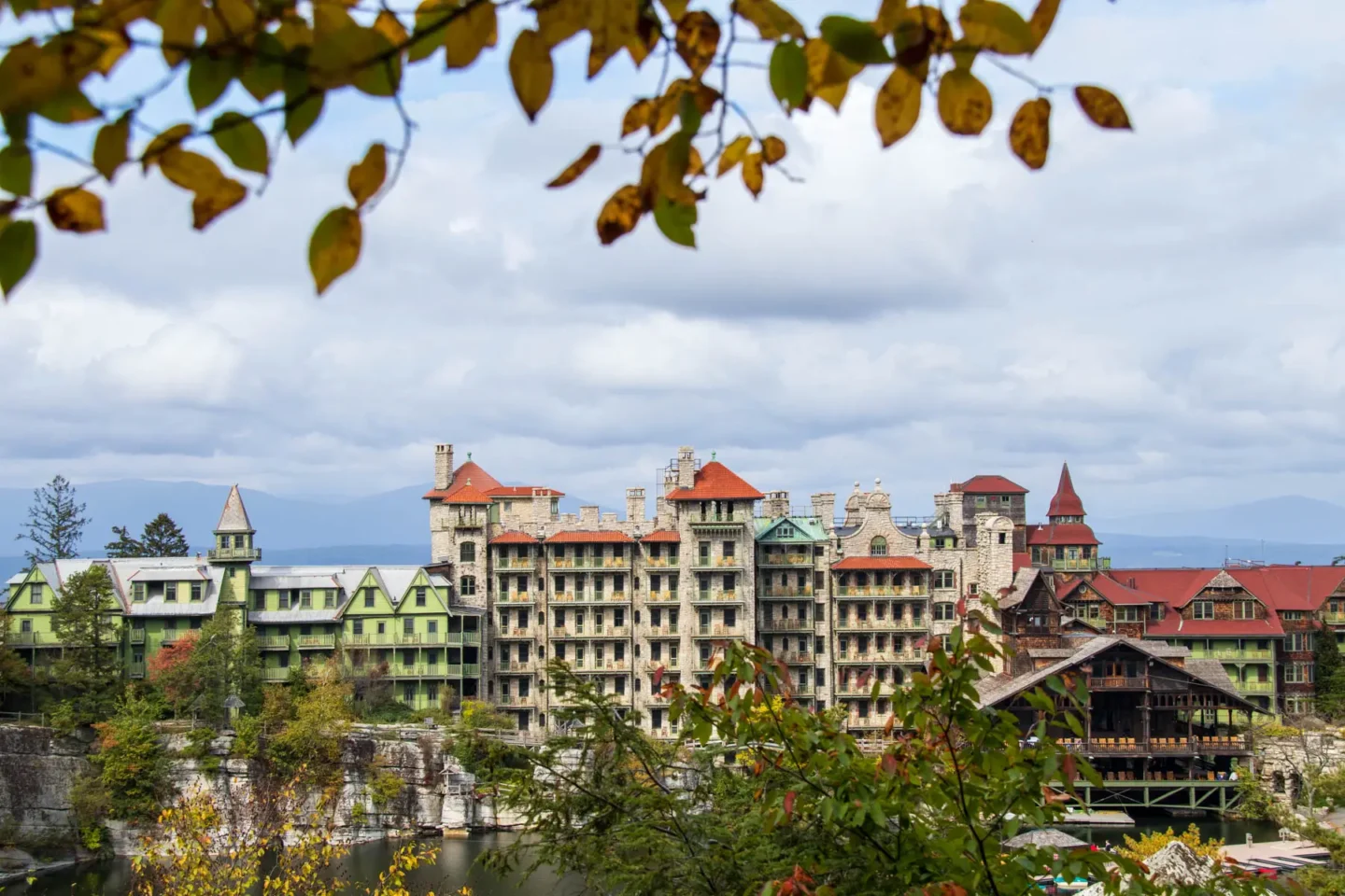 view of mohonk house an intricate hotel in new paltz with tall uneven buildings and lots of windows.