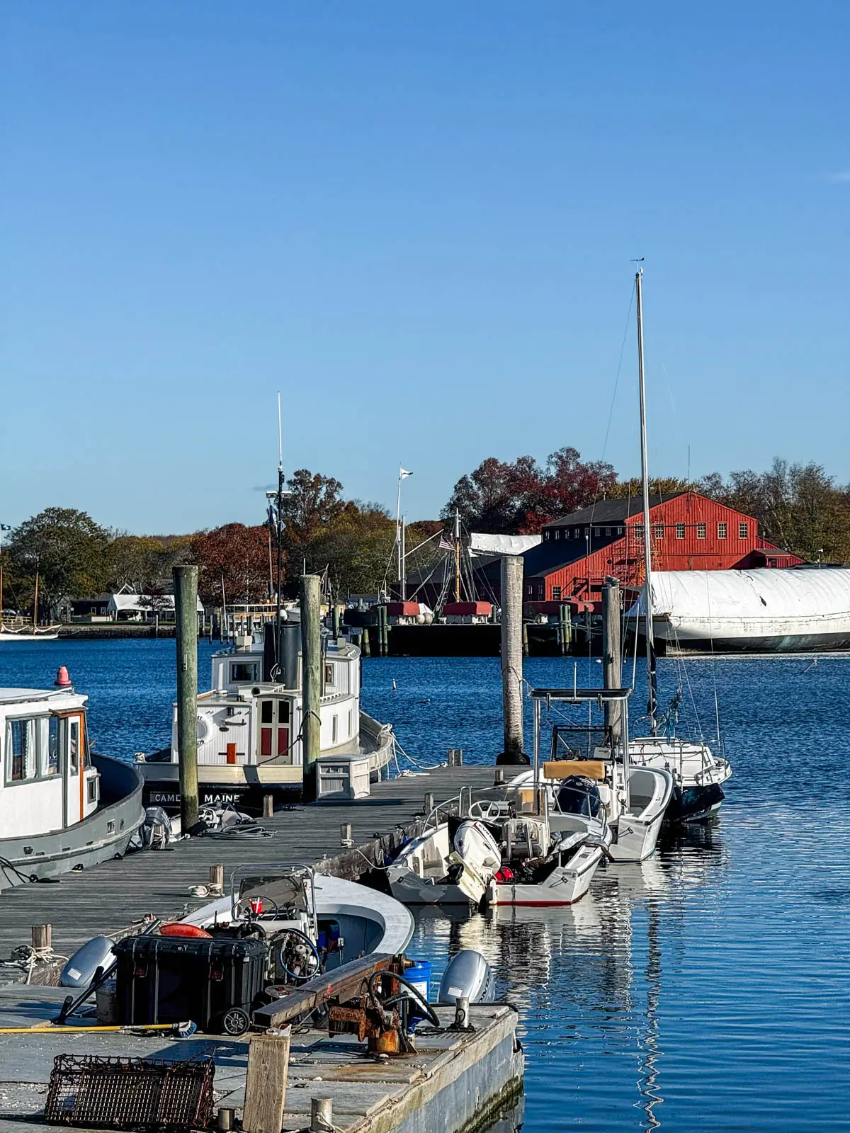 white ships along a dock with blue water and blue sky above.