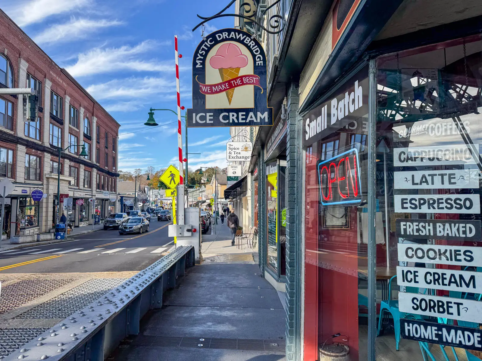 downtown mystic in fall with "Mystic Drawbridge Ice Cream" sign hanging from a store on the right.